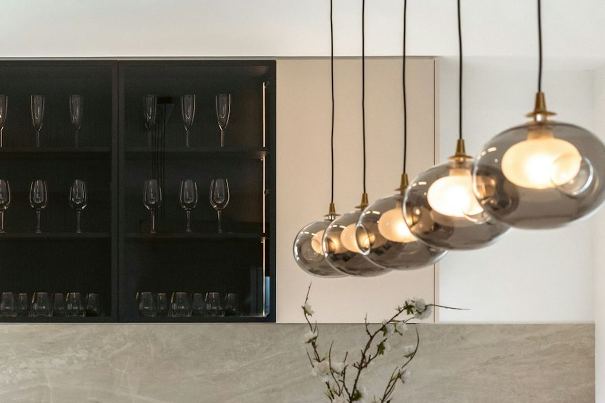 Row of glass pendant lights installed above a kitchen island